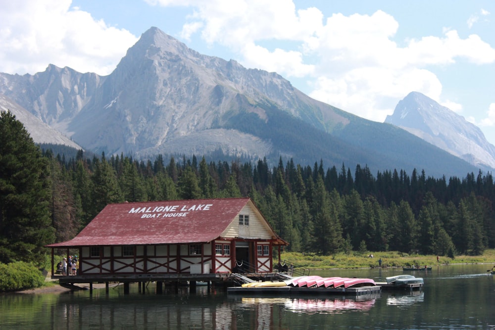 Un edificio su un molo vicino a un lago con le montagne sullo sfondo