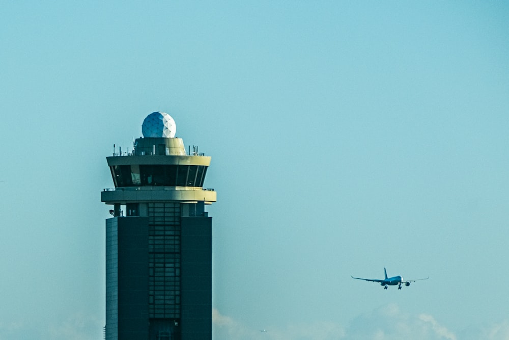a plane flying over a tall tower