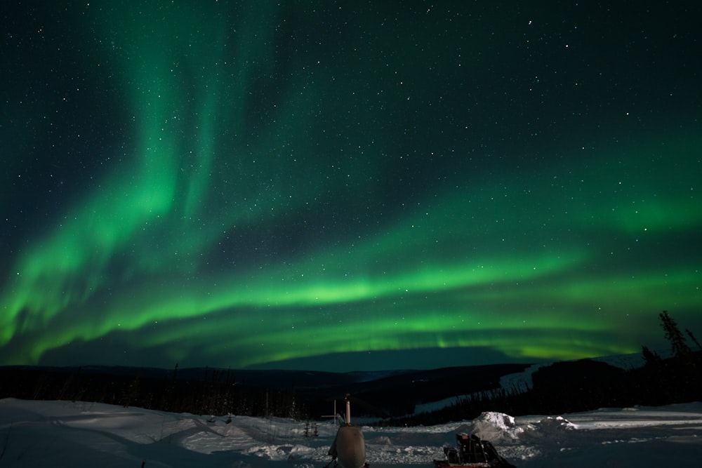 a green and purple sky over a snowy landscape