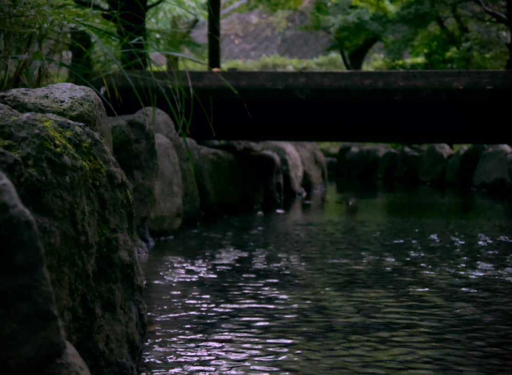 a river with rocks and a bridge