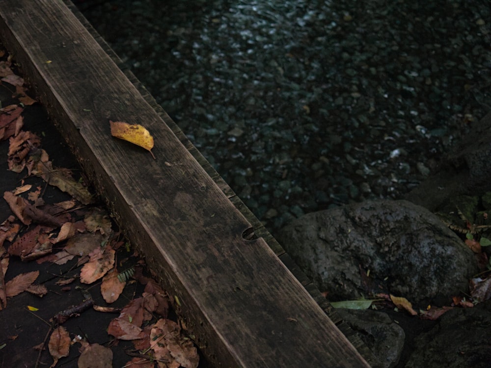 a wooden bench next to a body of water