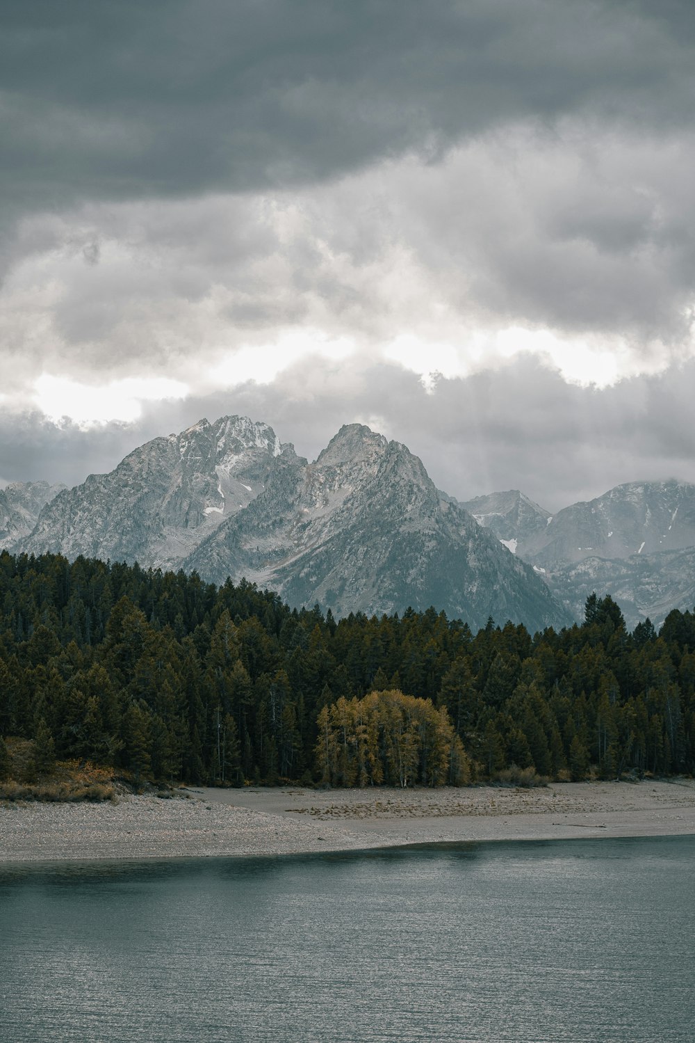 a lake with trees and mountains in the background