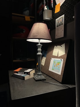 A focused scholar working late in a modern study space illuminated by warm desk lighting.