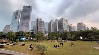 A vibrant urban park with people enjoying green spaces and modern benches