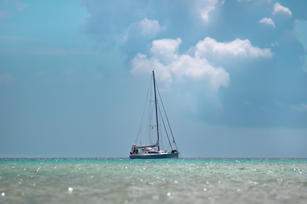 Helderblauwe zee met een zeilboot in het water