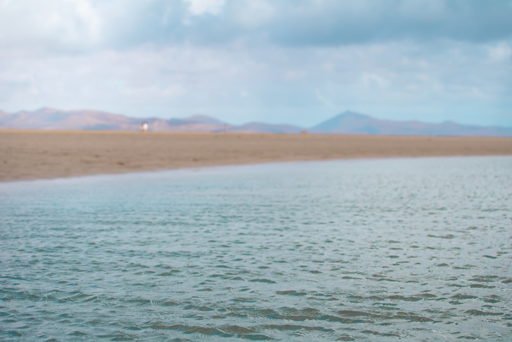 a body of water with hills in the background