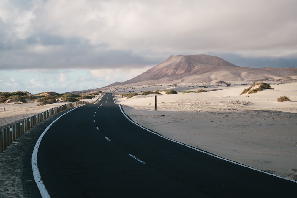 Une route avec du sable et des collines en arrière-plan