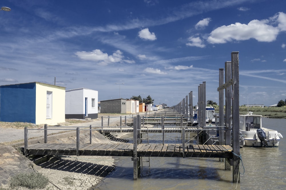 a dock with a boat and buildings in the background