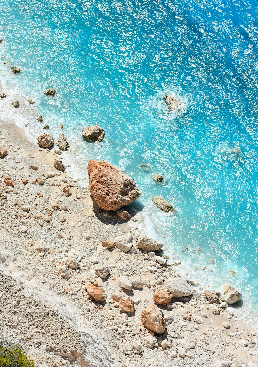 a rocky beach with a body of water in the background