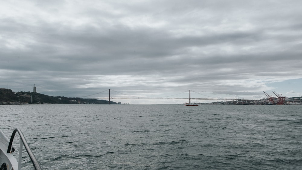 a body of water with a bridge and a tower in the distance