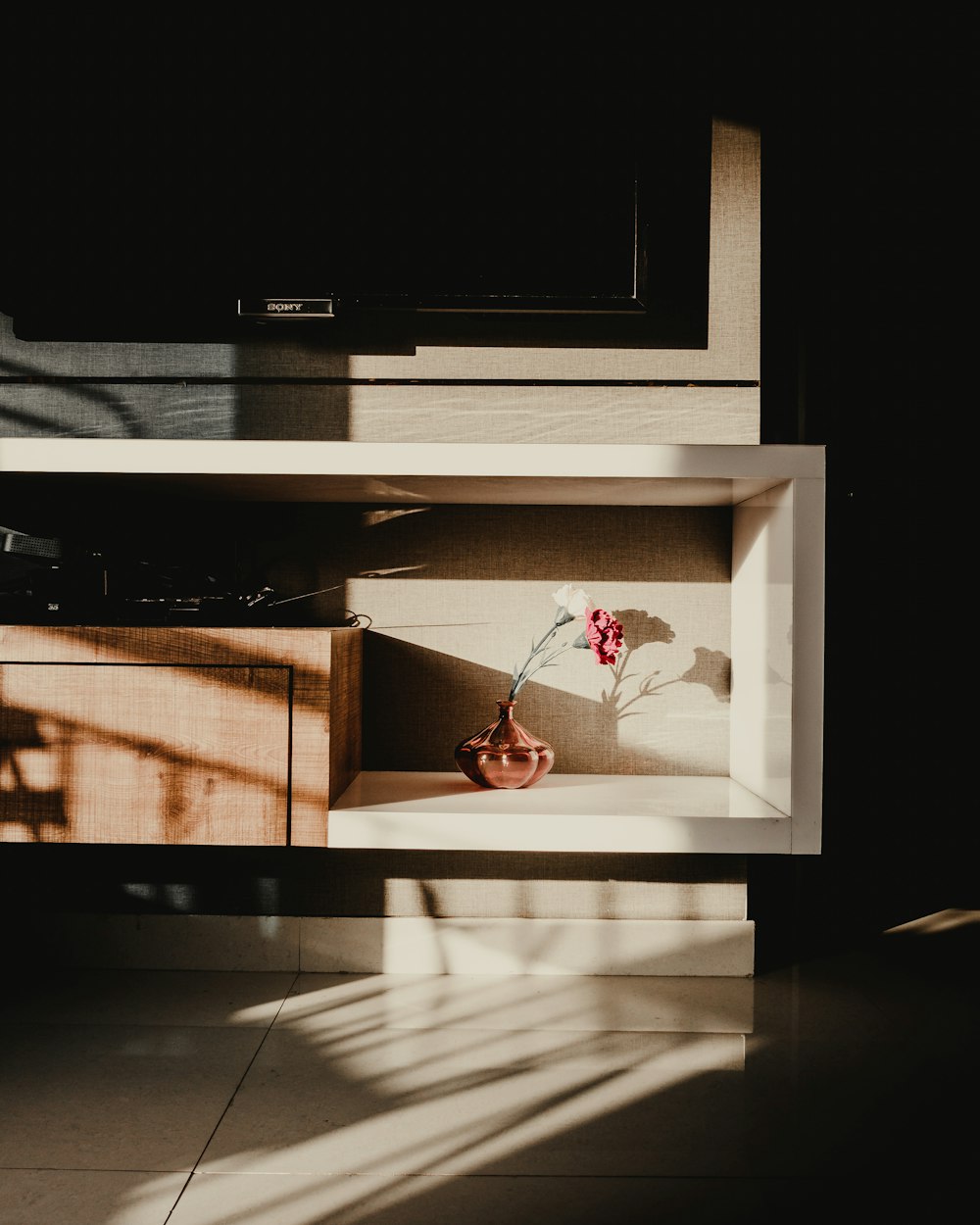 a vase with flowers on a shelf