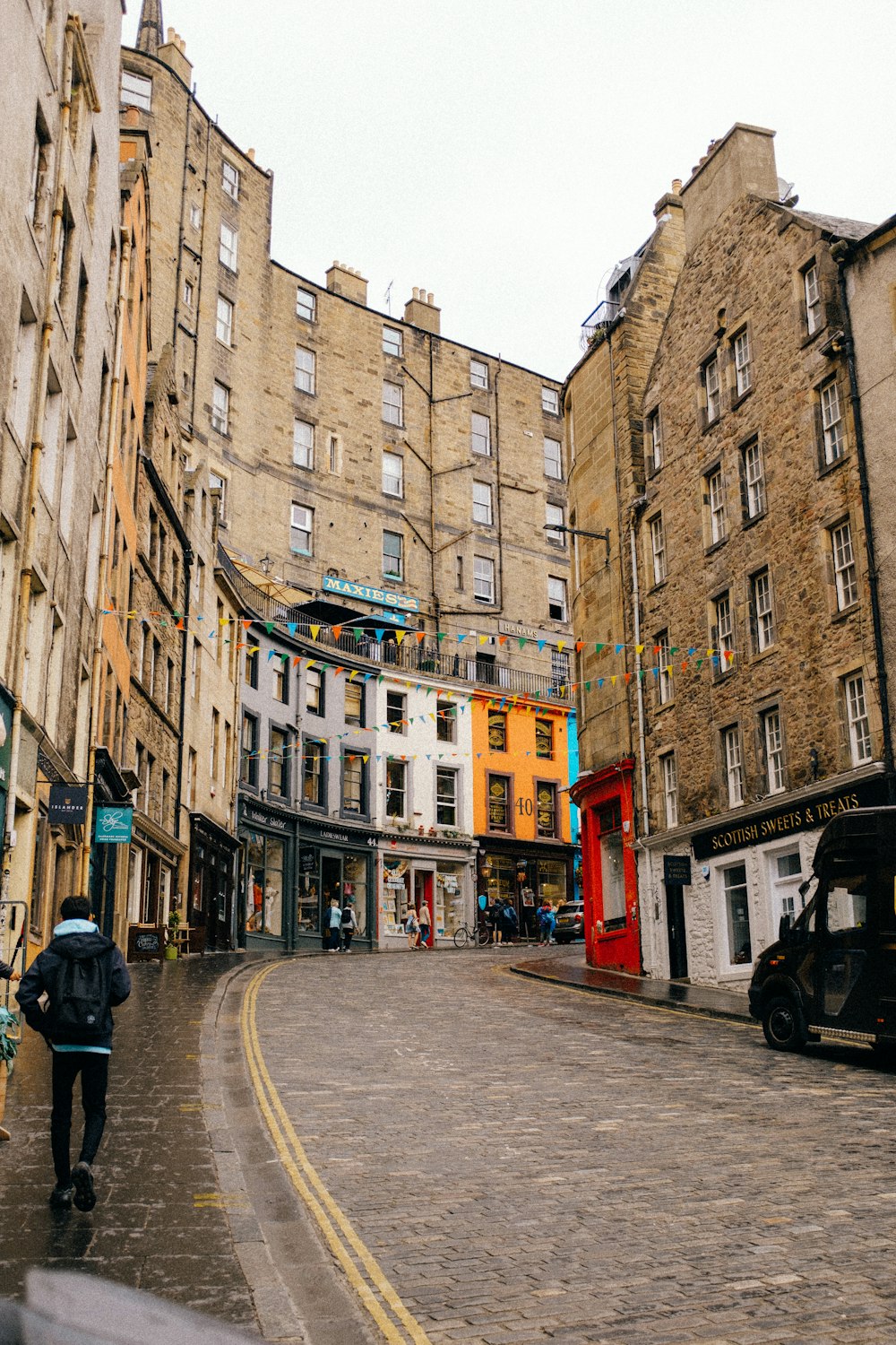 a person walking on a street between buildings