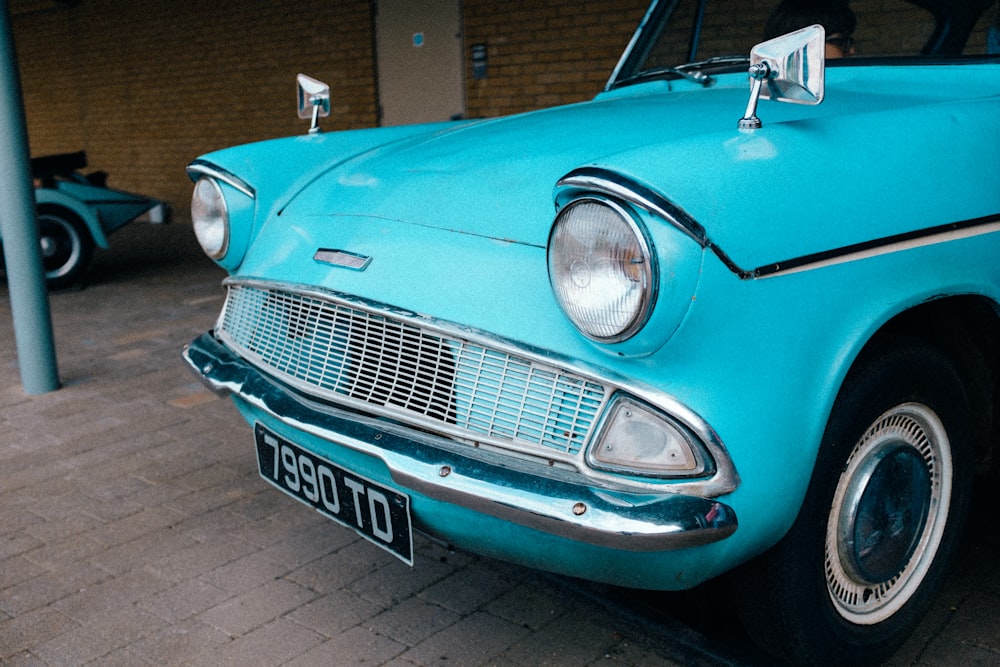 a blue car parked on a brick road