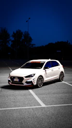 a white car parked in a parking lot at night