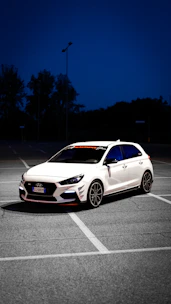 a white car parked in a parking lot at night