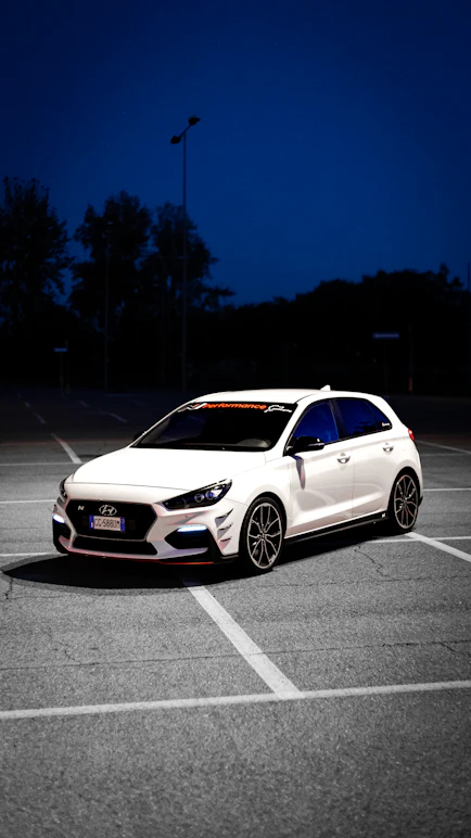 a white car parked in a parking lot at night