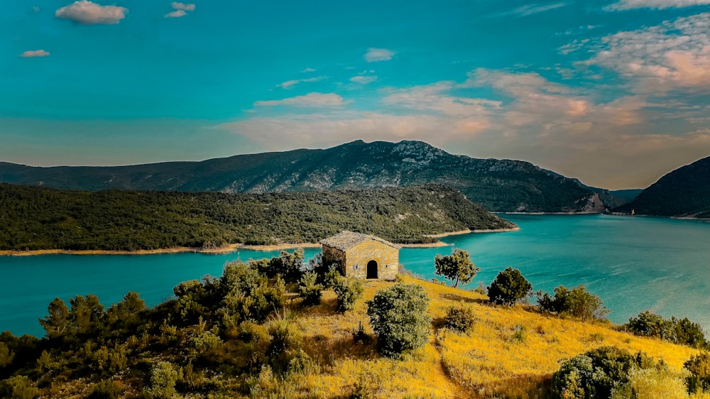 a building on a hill by a body of water