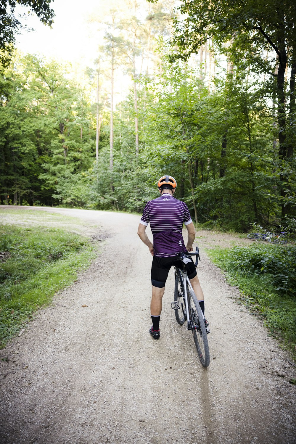 a man riding a bicycle on a path in the woods