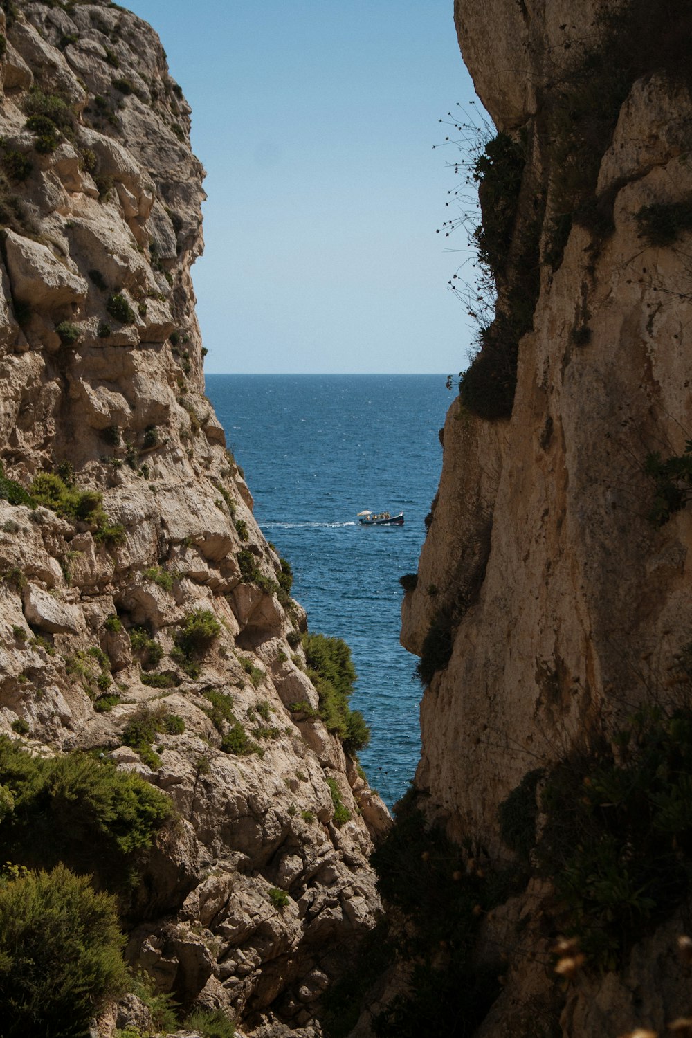 a cliff side with a body of water in the distance
