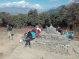 A group of trekkers resting with panoramic views of snow-capped peaks at Tungnath temple