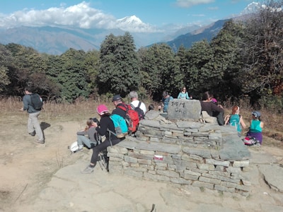 Group of hikers resting on a mountain peak enjoying the view.