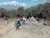 A group of hikers resting on a scenic overlook with vast mountain views.