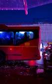 Night shot of a red and white VIP transfer vehicle illuminated by city lights