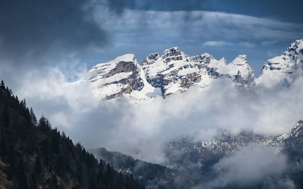 A mountain with clouds below — Madonna di Campiglio, Italy