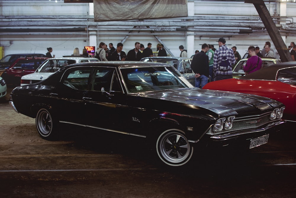 a group of people standing around a car show