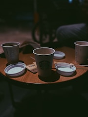 Warm coffee cups on a wooden table in a casual setting.