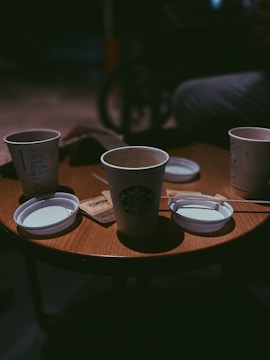 Warm coffee cups on a wooden table in a casual setting.