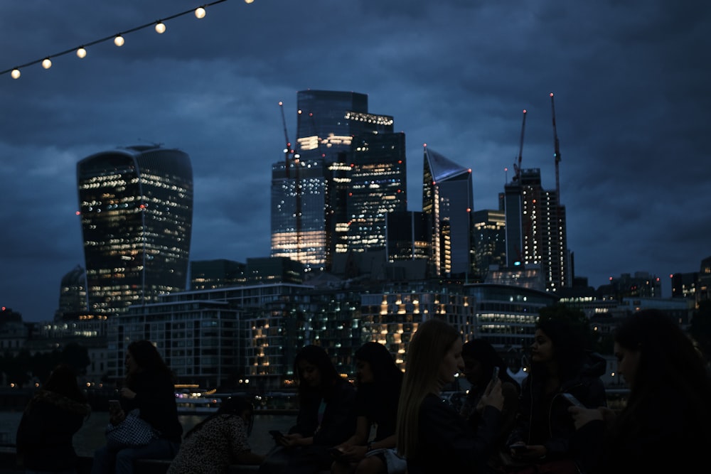 a group of people sitting in front of a city skyline