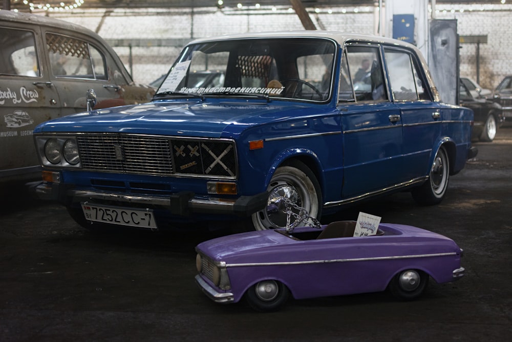 a blue car parked next to a purple car