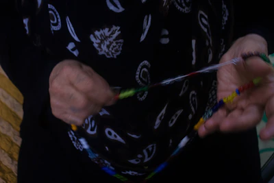 Artisan carefully threading colorful beads onto a string.