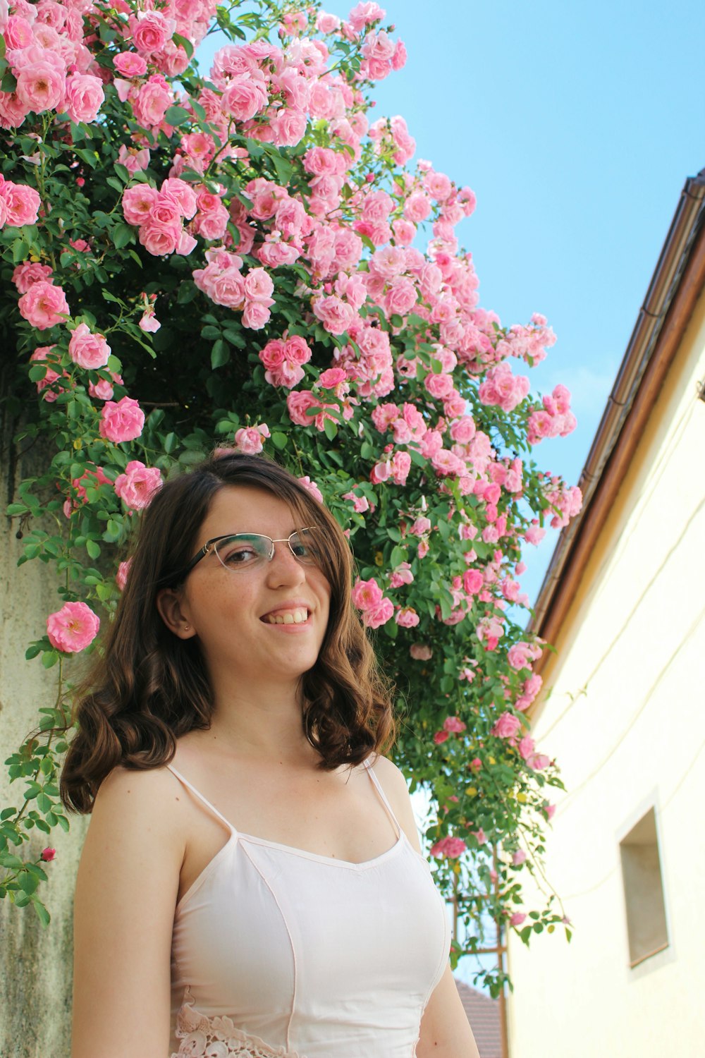 a woman standing in front of a flowering tree