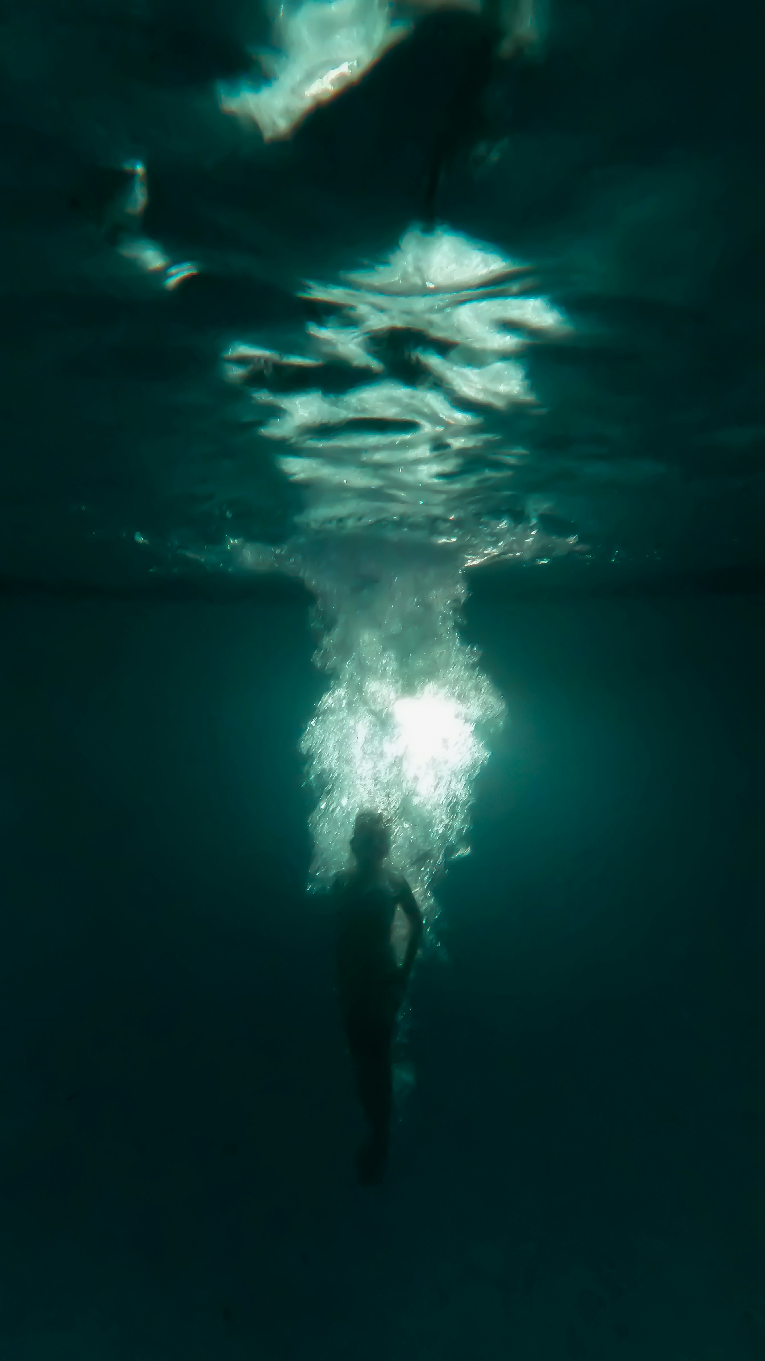 a person standing in front of a large light in the dark