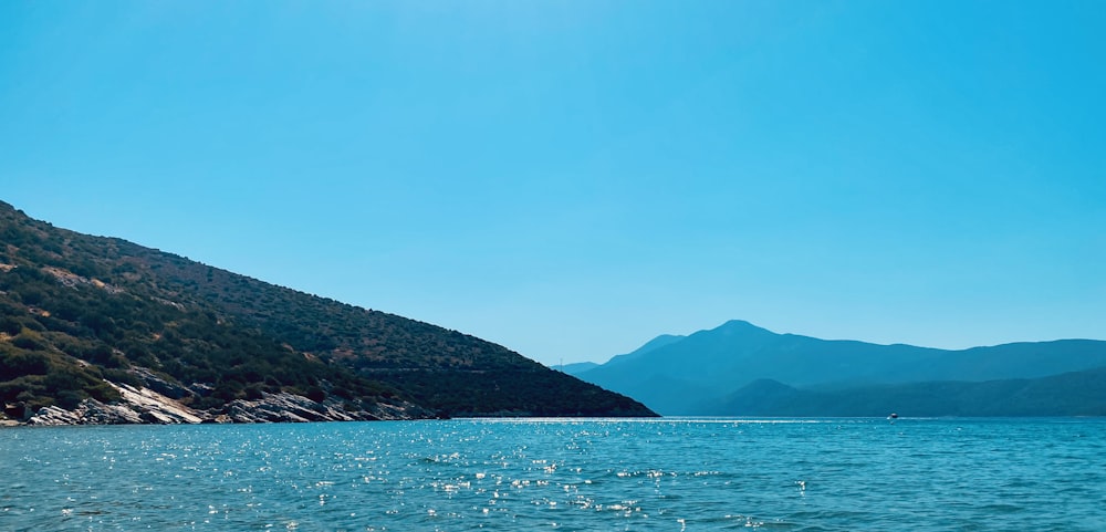 a body of water with hills in the background