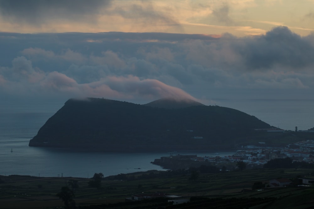 a large mountain next to a body of water