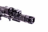 A close-up view of a firearm accessory with detailed engravings and mounted components, showcasing intricate metalwork and a tactical design.
