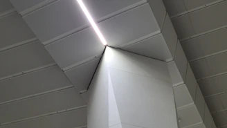 A sleek, minimalist office space with architectural lines and a subtle cross-shaped shadow on the wall.