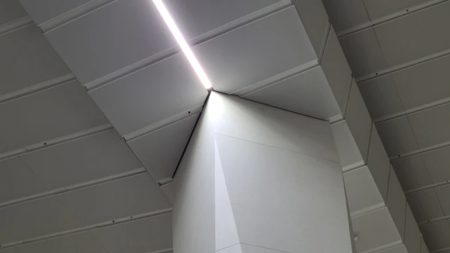 A sleek dark luxury minimalist design studio workspace with geometric lines and subtle electric cyan lighting accents.