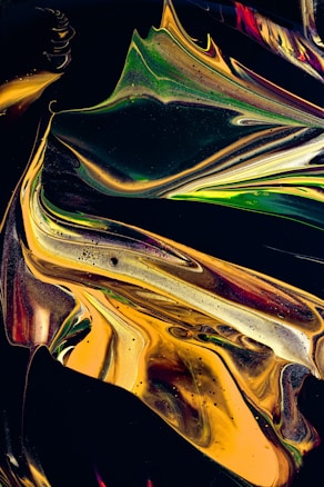 Swirling patterns of vibrant colors, primarily gold, green, and hints of red, intertwine against a dark background. The fluid, abstract design features smooth curves and gradients, creating a dynamic and visually striking composition.