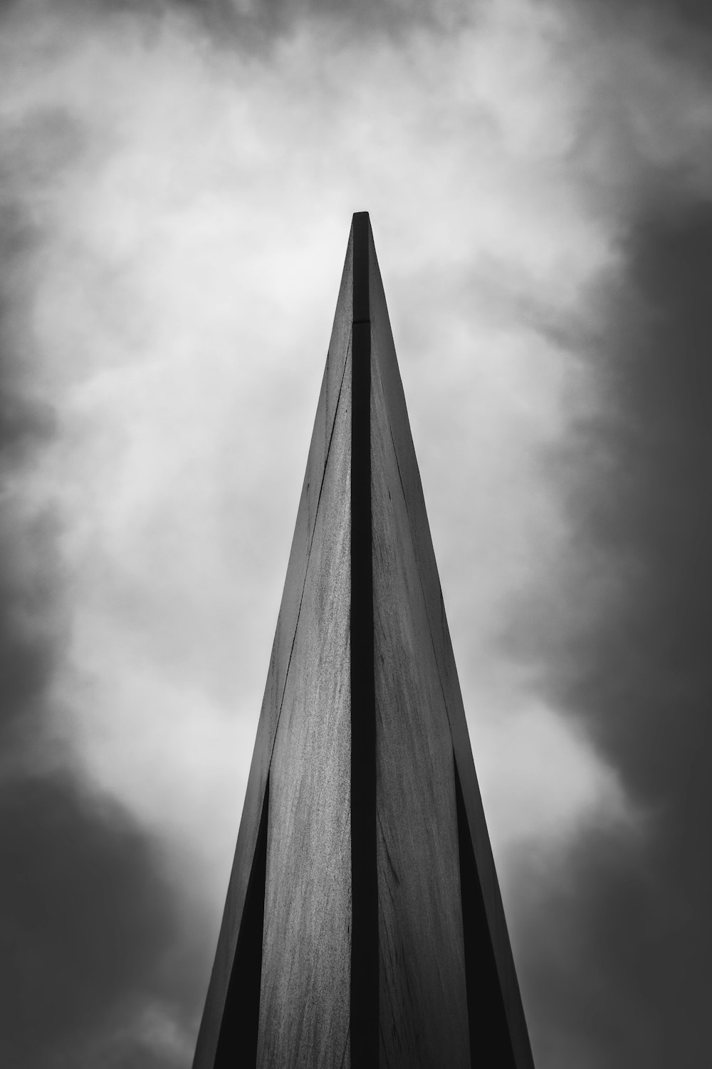 a tall tower with clouds in the background