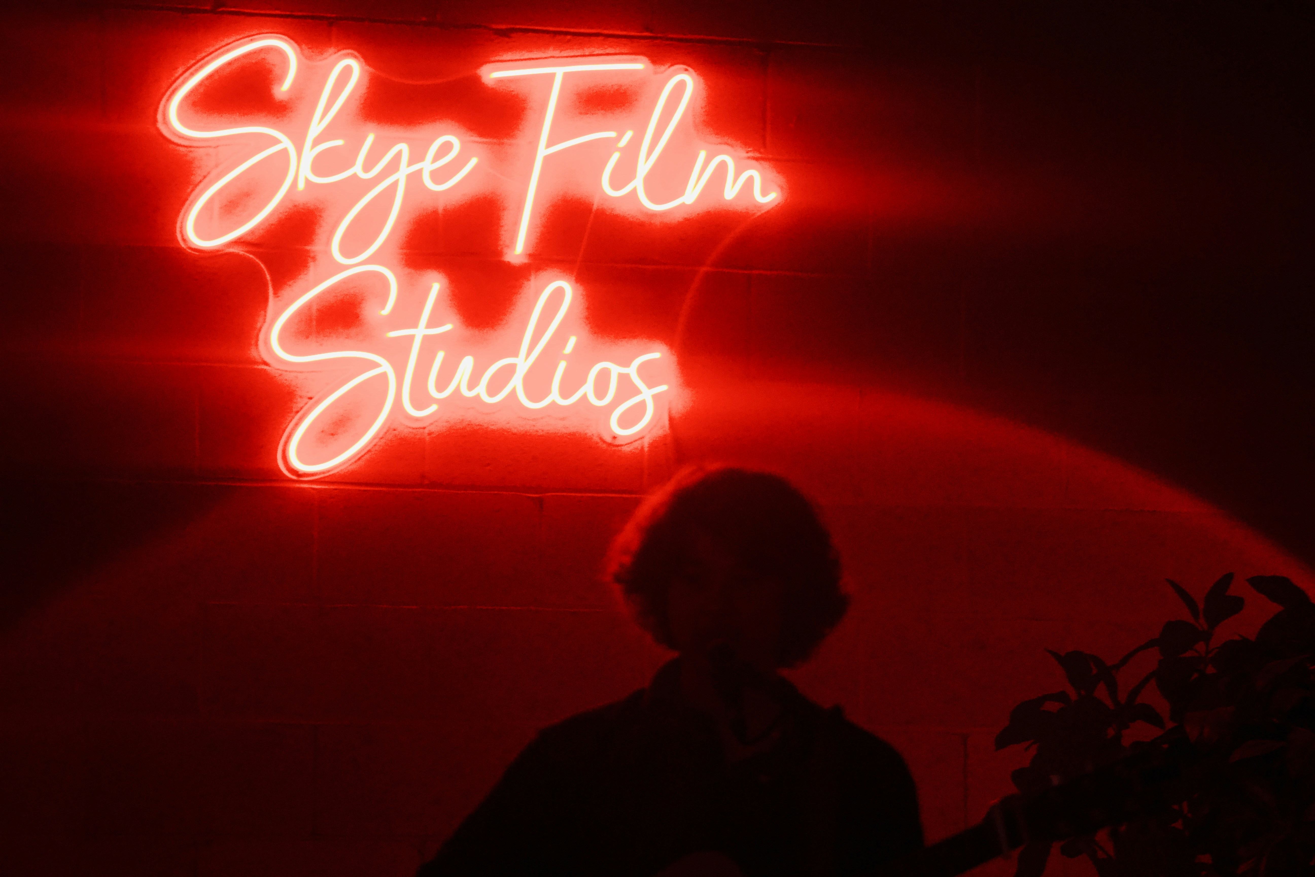 a person standing in front of a red wall with white writing