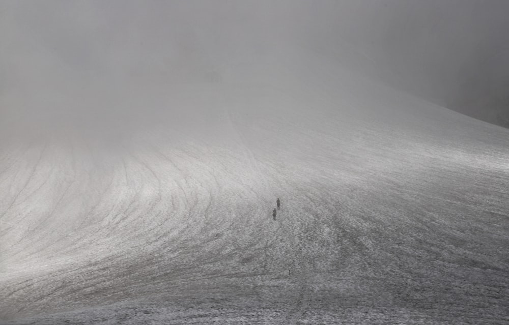 uma pessoa andando em uma colina nevada