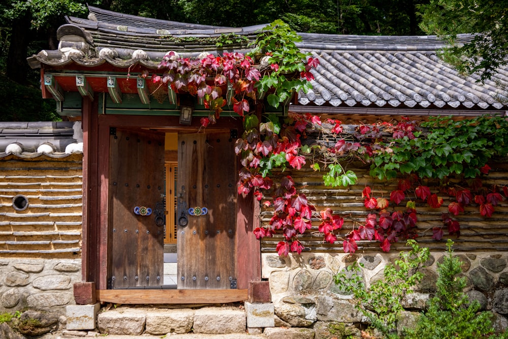 a house with a large door and flowers on the roof