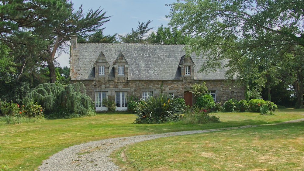 a stone house with trees and bushes