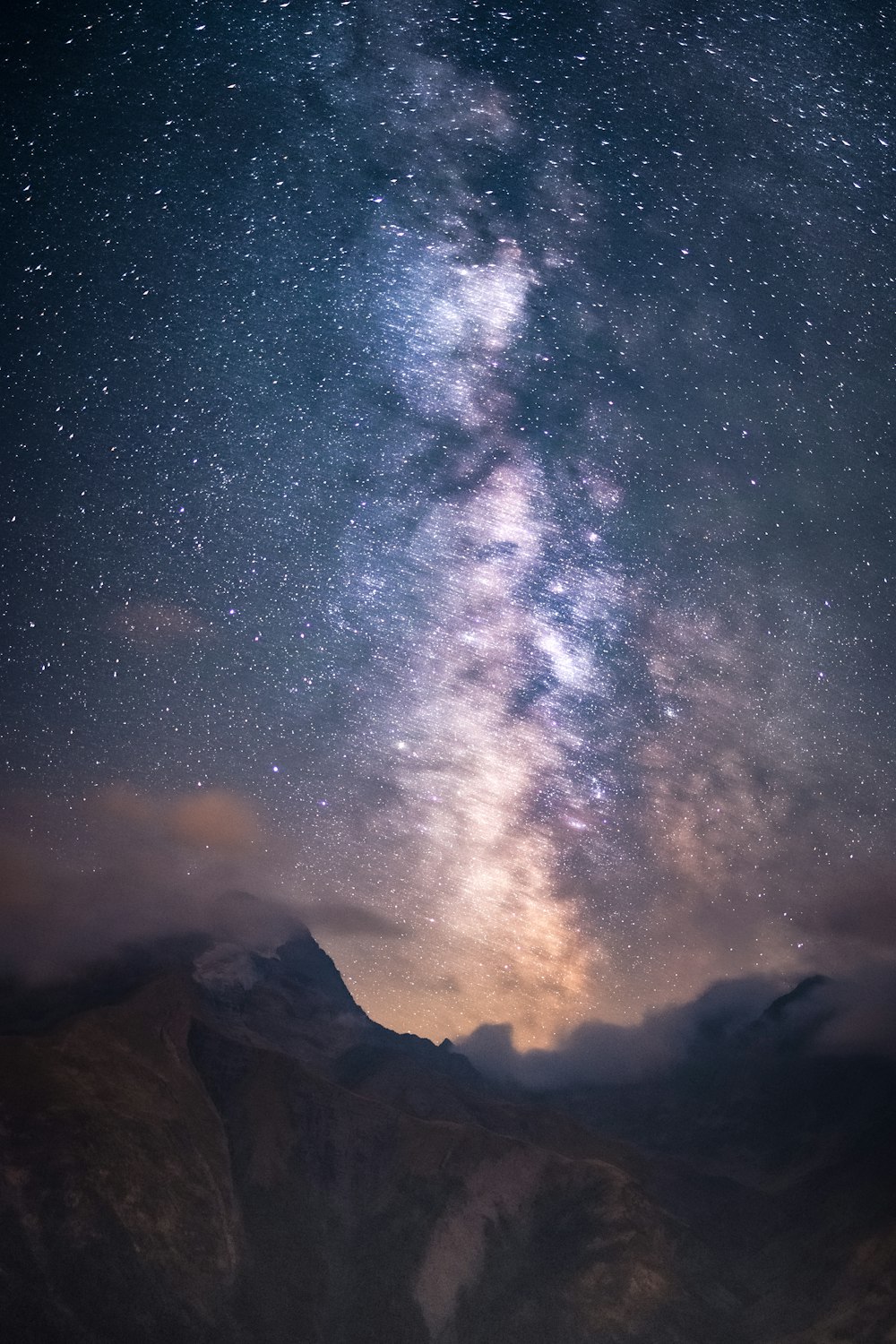 a starry night sky over a mountain range