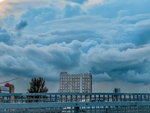 A wide-angle shot of a large commercial building equipped with lightning protection rods and grounding systems under a clear blue sky.