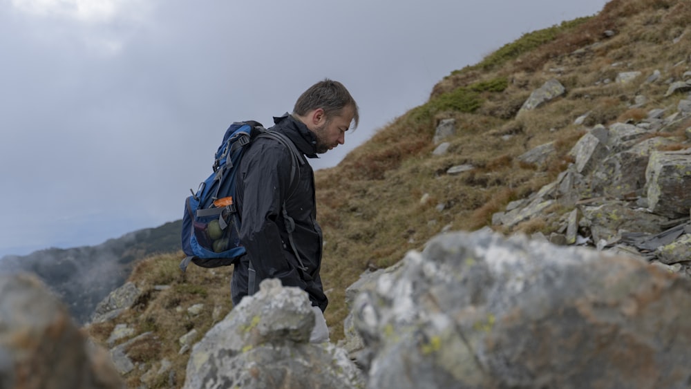 a man with a backpack on a rocky hill
